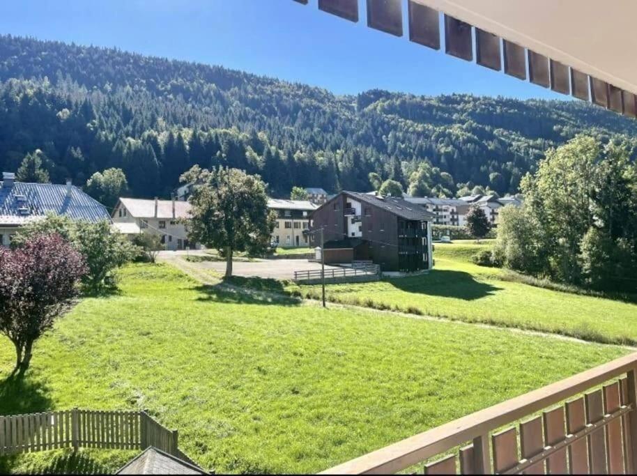 a view from the balcony of a house with a green yard at Winter Cocon in Mijoux