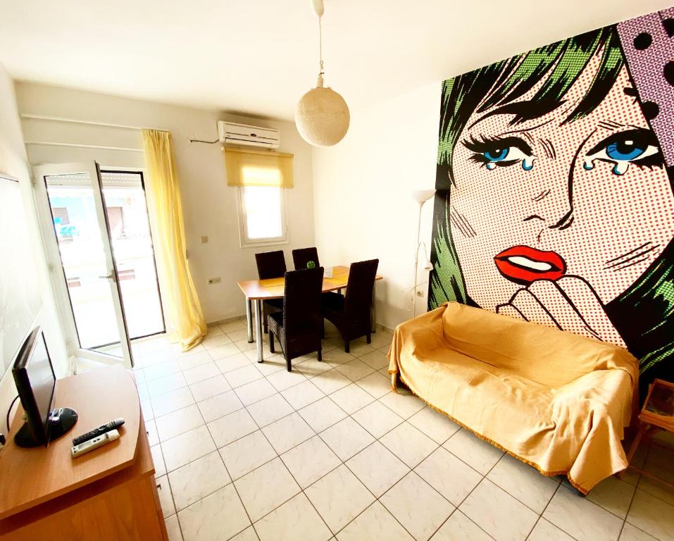 a living room with a large painting of a woman at Korona Beach Apartments I in Rethymno