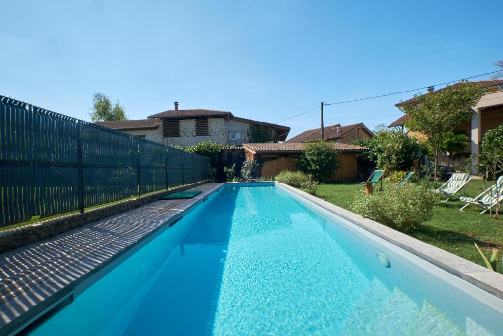 a swimming pool with blue water in a yard at Maison chez nous in Izeron