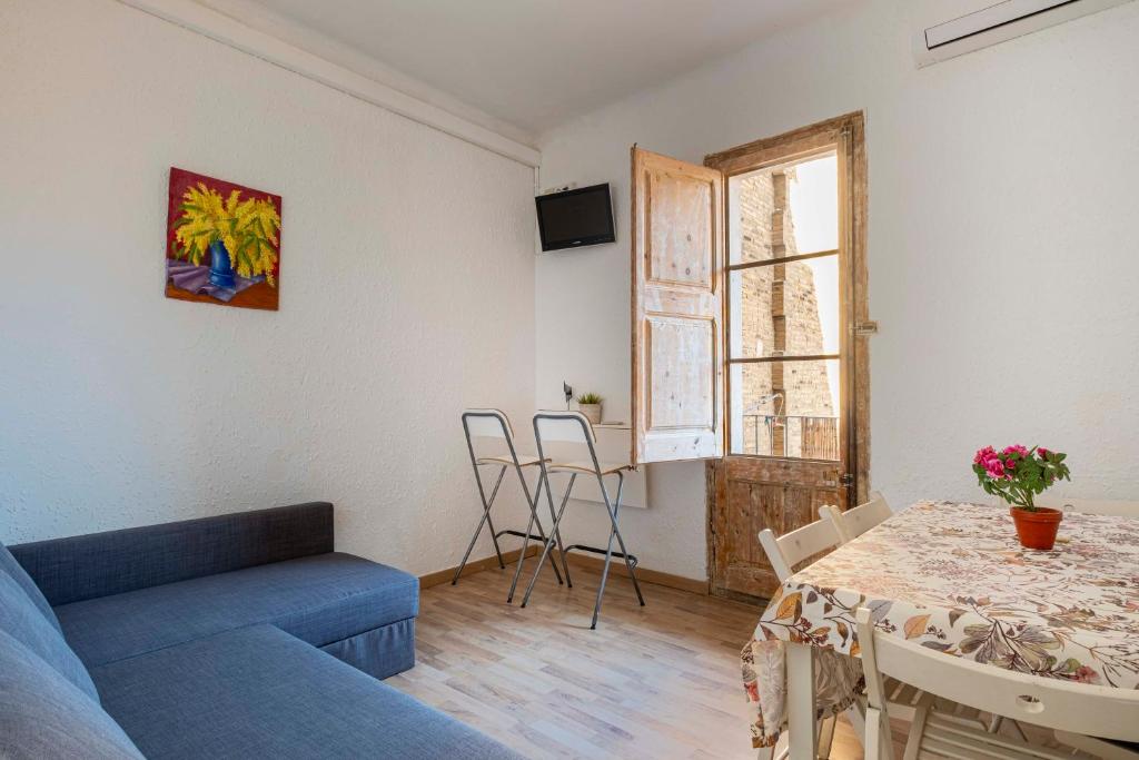 バルセロナにあるCentric Apartments Sagrada Famila 3のリビングルーム(青いソファ、テーブル付)