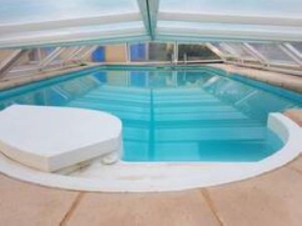 a large swimming pool with a blue floor at bungalow au calme in Saint-Savournin