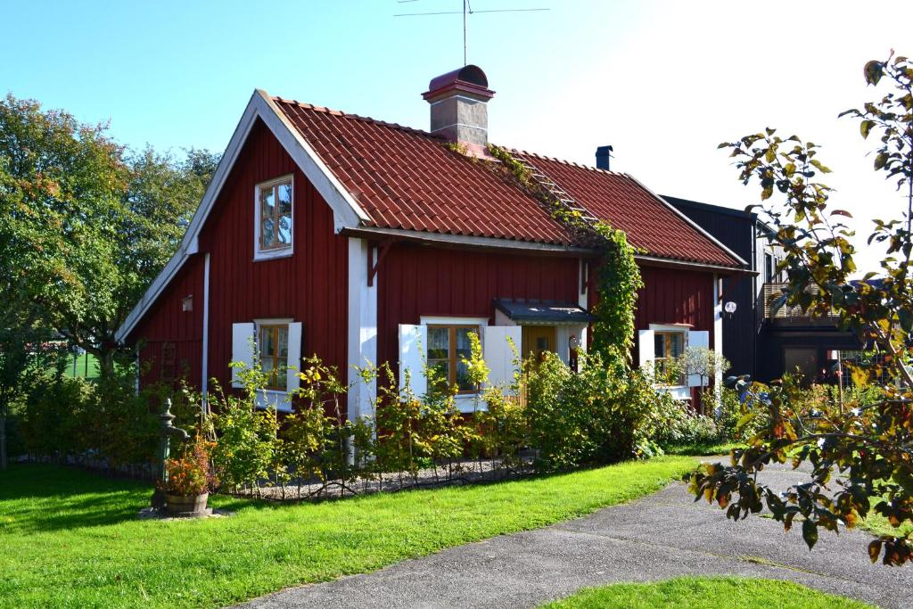 una casa roja con techo rojo en Stuga med lantlig känsla nära Örebro city en Örebro