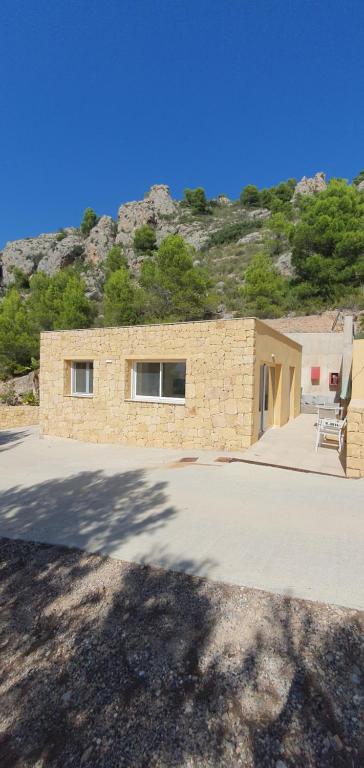 uma casa de pedra com uma cadeira em frente em Casita Puig Campana Finestrat em Finestrat