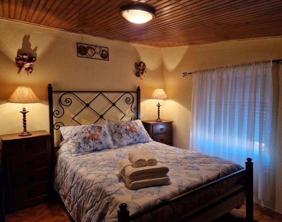 um quarto com uma cama com toalhas em AL - Casa dos Alentejanos 