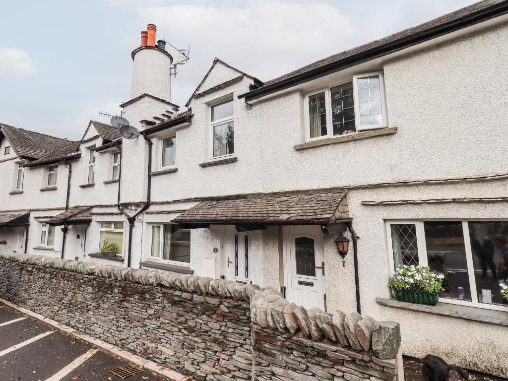 a building with a stone wall in front of it at 6 Calgarth View in Windermere