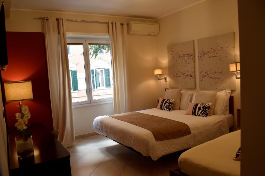 ローマにあるホリデー ア サン ピエトロのベッド2台と窓が備わるホテルルームです。