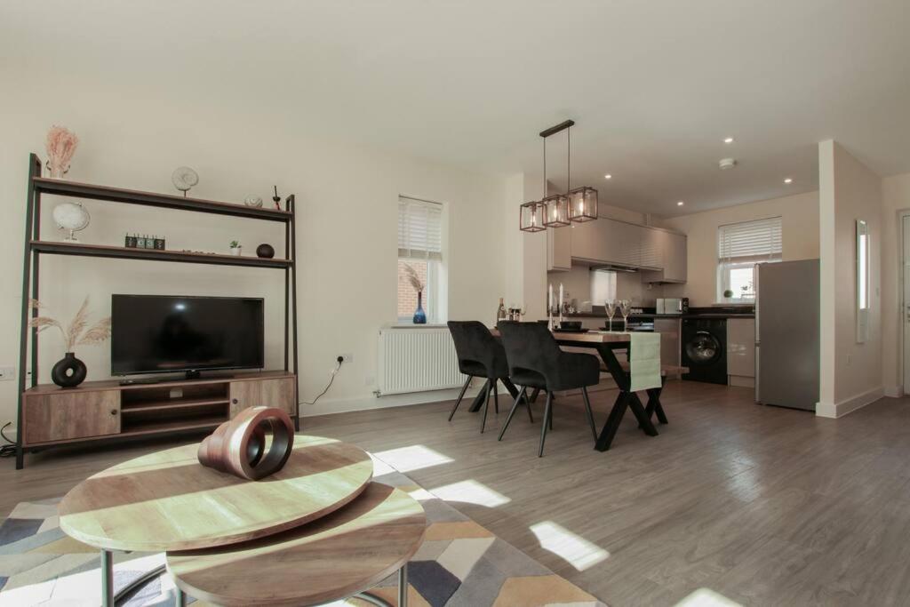 a large living room with a table and a kitchen at Luxury Colchester House in Colchester