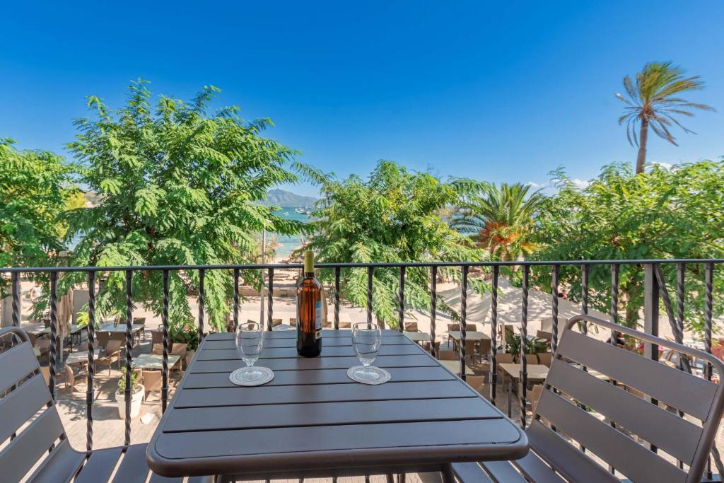 a table on the balcony with a view of the beach at Vora Mar Beachfront Apartment by Sealand Villas in Port de Pollensa