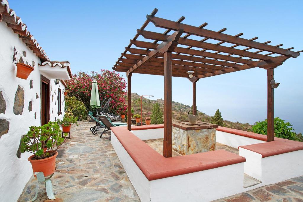 蒂哈拉費的住宿－La Chirlaca，庭院设有木制凉亭和长椅