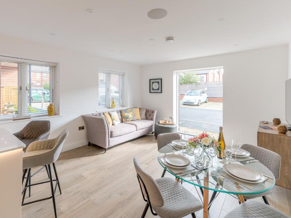 een woonkamer met een tafel en stoelen en een bank bij Pass the Keys Contemporary Apartment with Secure Parking in Shrewsbury