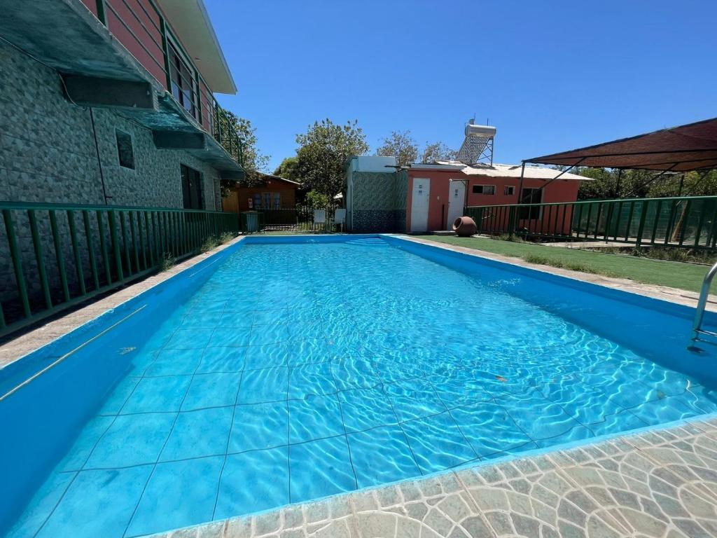 a swimming pool with blue water in a yard at CABAÑAS TIA FLOR in Pica