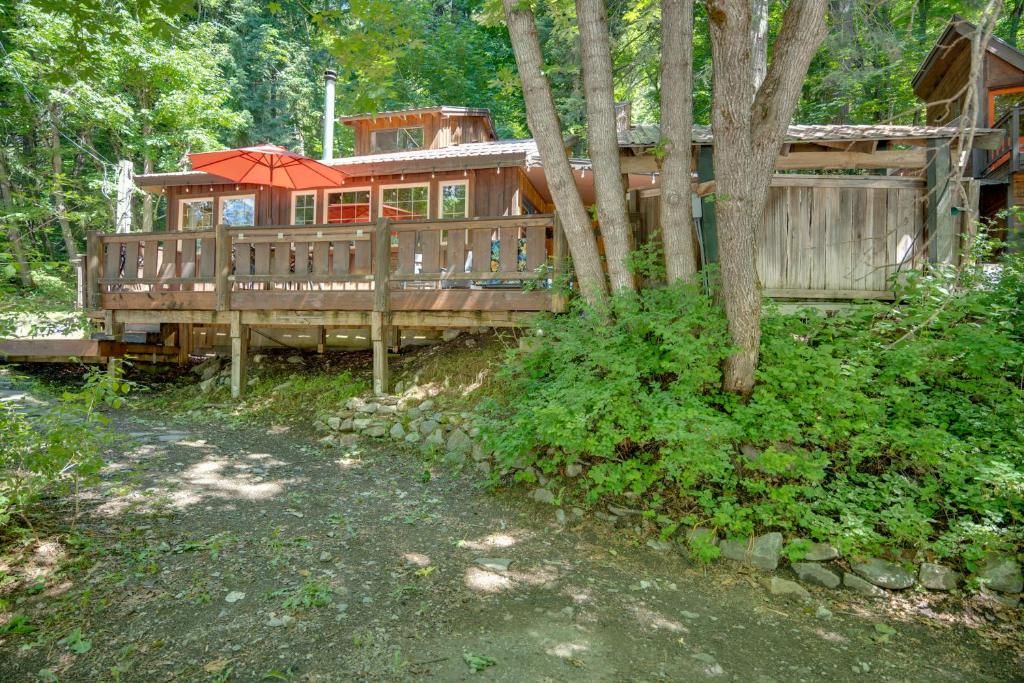 a large wooden house with an umbrella in the woods at Leavenworth Cabin with Private Hot Tub! in Leavenworth