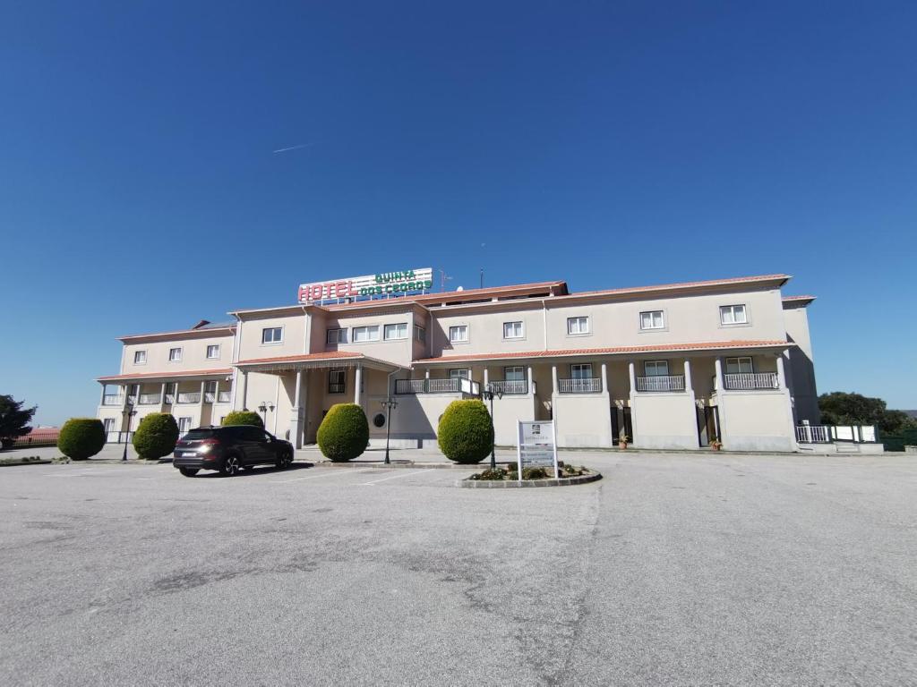 a building with a car parked in front of it at Hotel Quinta dos Cedros in Celorico da Beira