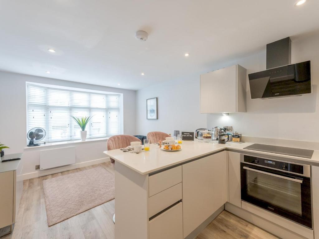 シュルーズベリーにあるPass the Keys Amaranth Stylish town centre apartmentの白いキャビネットとカウンタートップを備えたキッチン