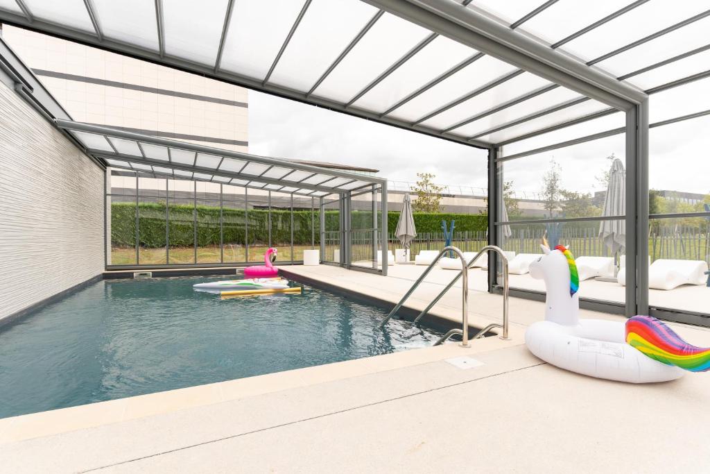a swimming pool with inflatable flamingos and inflatable tubes at Residhome Sénart in Lieusaint