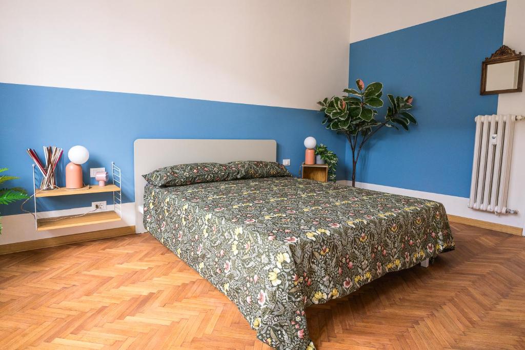 - une chambre avec un lit et un mur bleu dans l'établissement [700mStazioneCentrale]Ampio Trilocale con 2Balconi, à Trieste