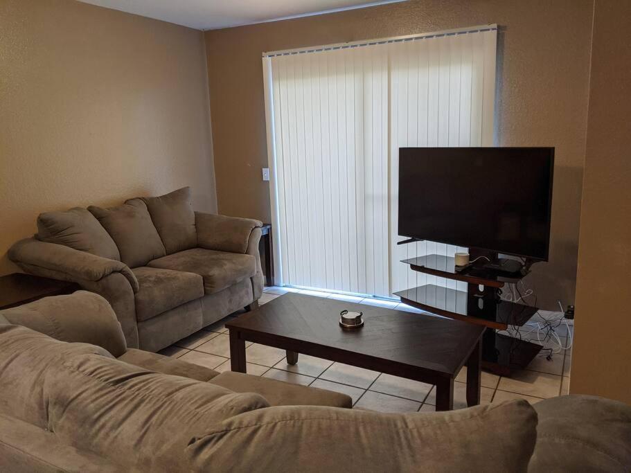 sala de estar con sofá y TV de pantalla plana en Snowbirds escape / vacation gateway #a en Englewood