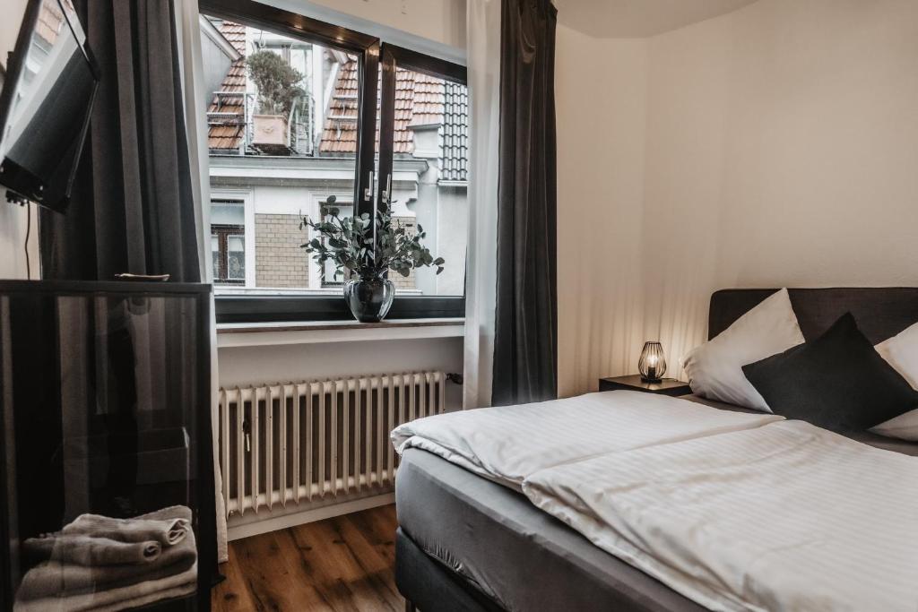 um quarto com uma cama e uma janela em Boutique Hotel Cologne em Colónia
