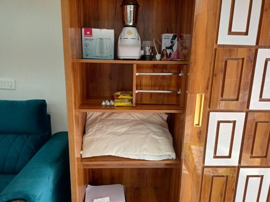 a book shelf with a bed in a room at 2BHK AC Service Apartment 303 in Pune