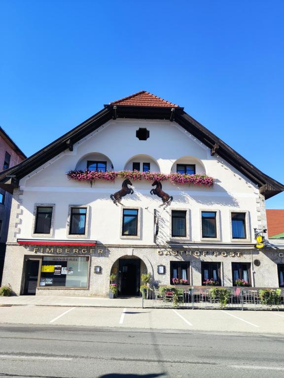 ein weißes Gebäude mit rotem Dach in der Unterkunft Gasthof Post in Frankenmarkt