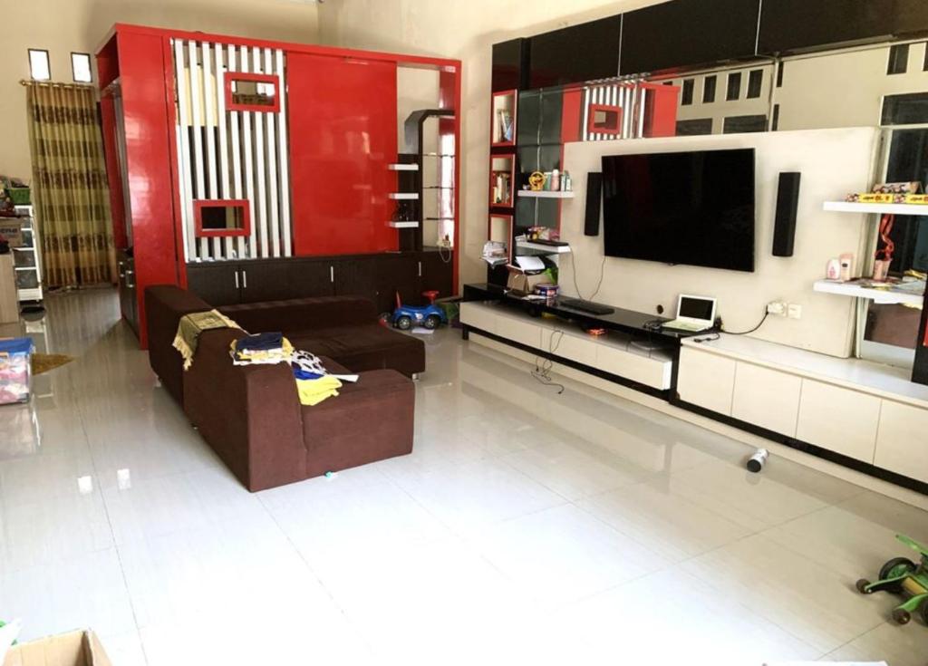 een woonkamer met een bank en een flatscreen-tv bij Felix guest house in Tegal