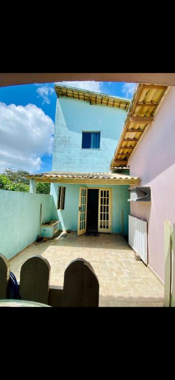 ein Gebäude mit einer Terrasse mit Stühlen davor in der Unterkunft Casa de Temporada Arraial do cabo in Arraial do Cabo