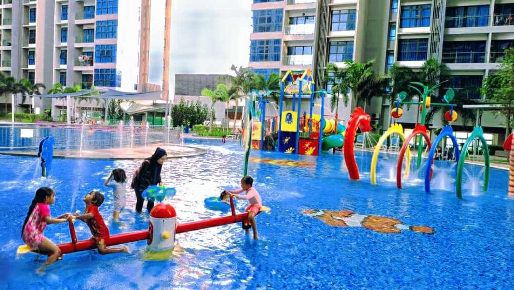 un groupe d'enfants jouant dans un parc aquatique dans l'établissement Atlantis Residence Melaka by YouBNB Homestay, à Malacca