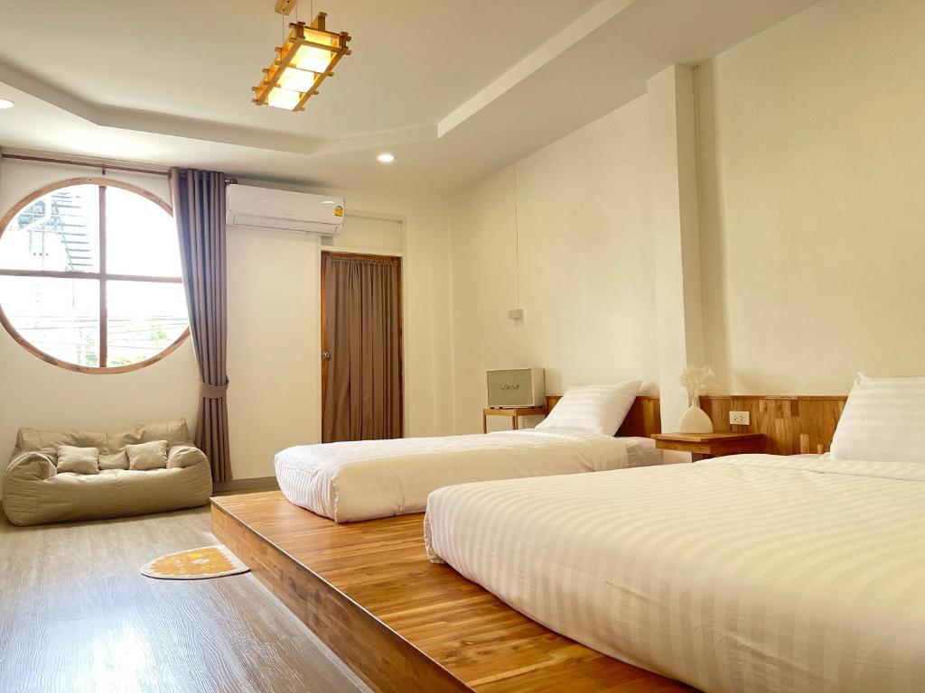 Cette chambre comprend 2 lits et une fenêtre. dans l'établissement Jinbo Betong Home Cafe’, à Betong