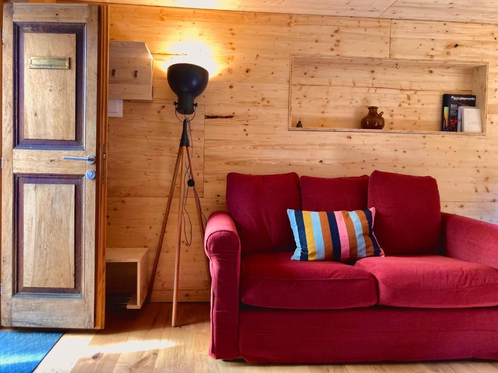 a living room with a red couch and a lamp at LA CÀ NOVA. South Switzerland cozy gate away. in Osco
