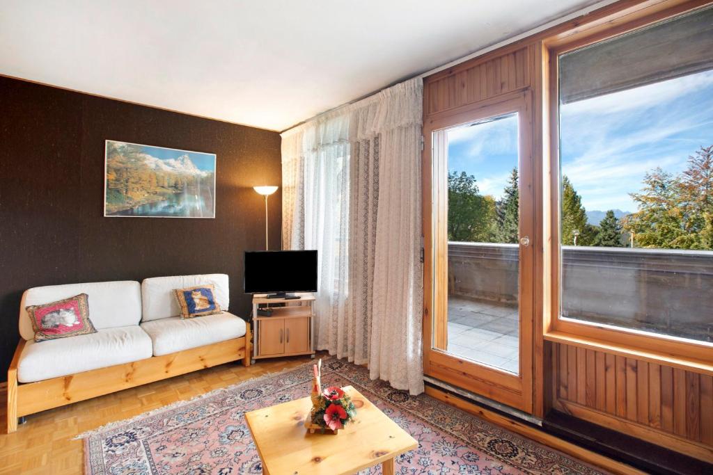 a living room with a couch and a large window at Augusta Praetoria Pila in Gressan