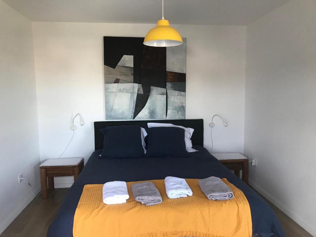 una camera da letto con un letto e due asciugamani di Le Lodge Park à La Rochelle a La Rochelle