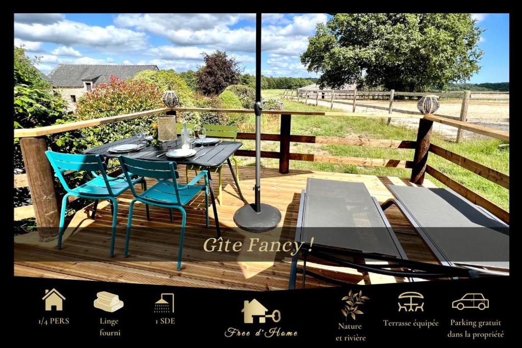 a wooden deck with a table and chairs on it at Gîte Fancy, Vallée du Scorff, Nature 2-4 personnes in Arzano