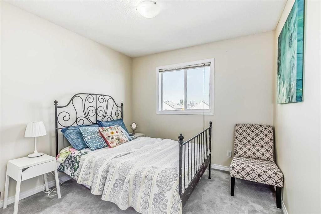 um quarto com uma cama, uma cadeira e uma janela em Calgary Mountain Gorgeous Single House Close Airport & Free Parking em Calgary