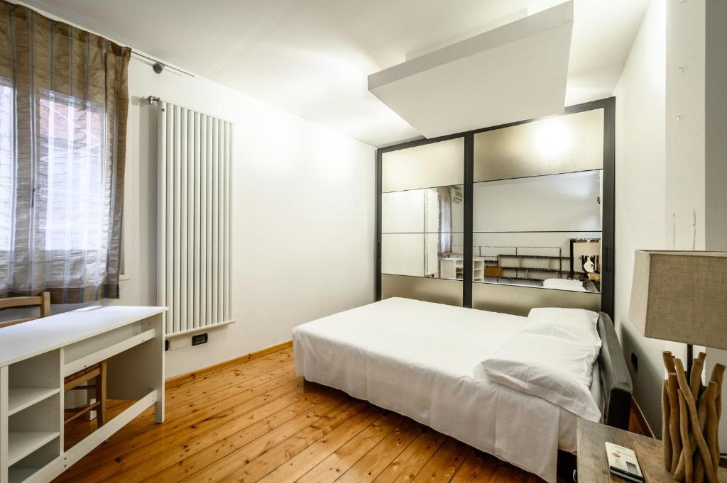 sypialnia z łóżkiem z dużym lustrem w obiekcie Piazza Maggiore - Central Loft con Patio w Bolonii