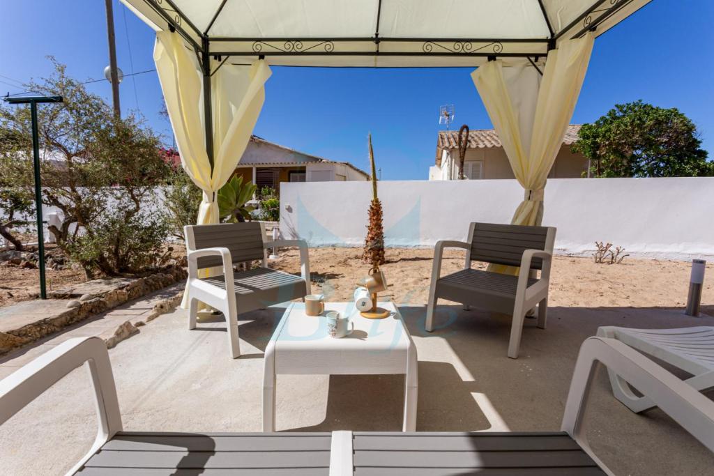 un patio con 2 sillas, una mesa y una tienda de campaña en BLife Faro Beach Hostel en Faro