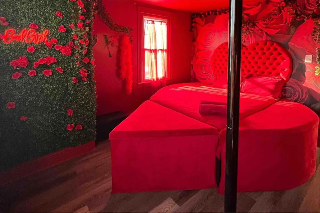 a red bedroom with a red bed and a window at TheHottieHouse: Fun Fantasy Experience Apt On Blvd in Philadelphia