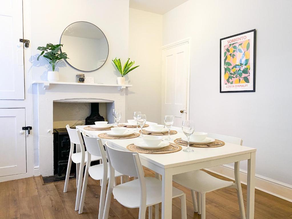 a white dining room with a white table and chairs at Stylish 3-bedroom home in Canterbury City-Centre - Superb Location! in Canterbury