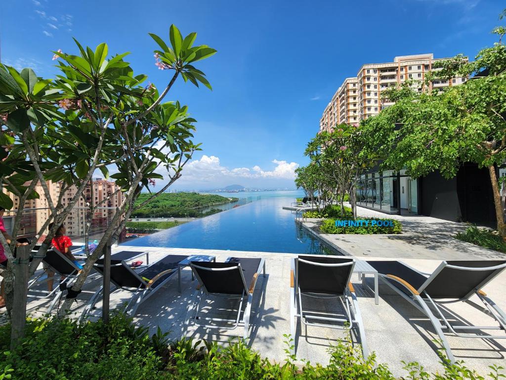 a view of a river with chairs and buildings at Urban Suite - George Town in Jelutong