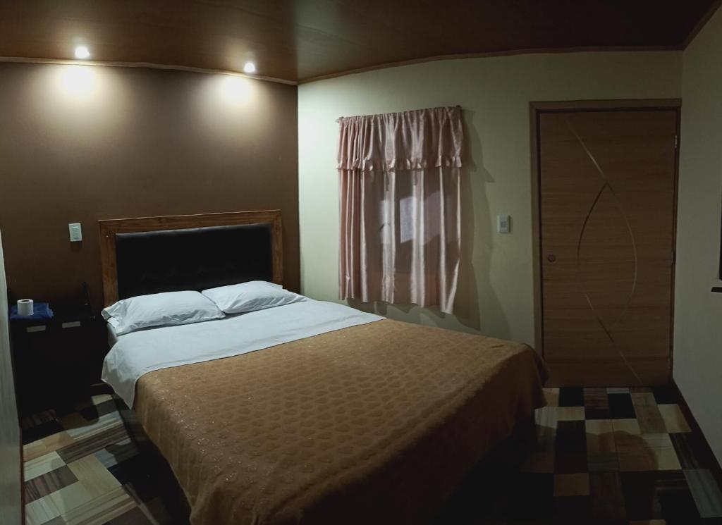 Un dormitorio con una cama grande y una ventana en Hotel la guaneña, en Ipiales