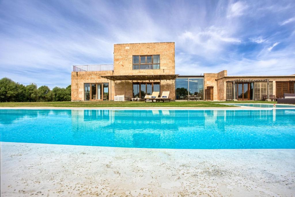une grande piscine en face d'une maison dans l'établissement Finca Son Coranta, à Campos