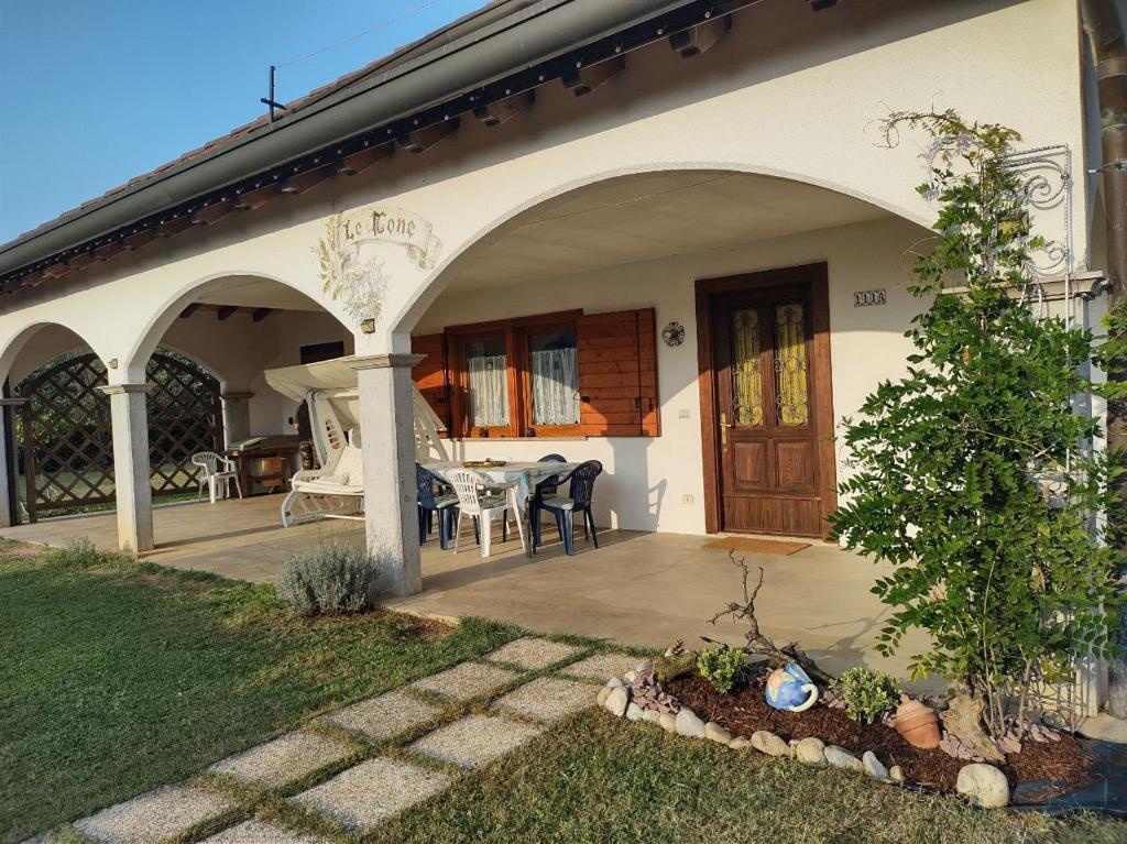 Casa blanca con patio con mesa y sillas en Cottage "Le None"-villa e giardino, en Gonàrs