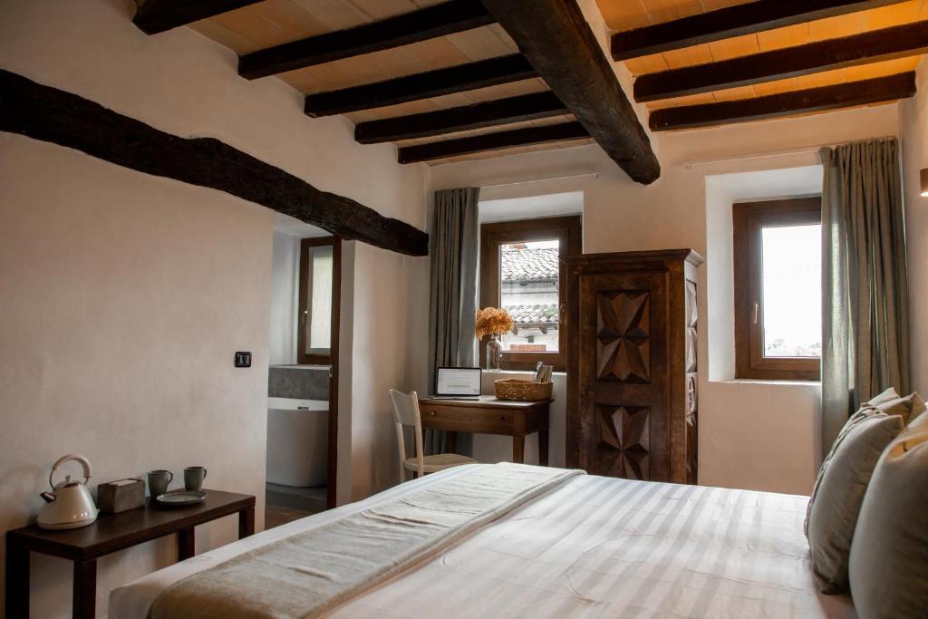 a bedroom with a bed and a desk and windows at Dimidium in Canossa