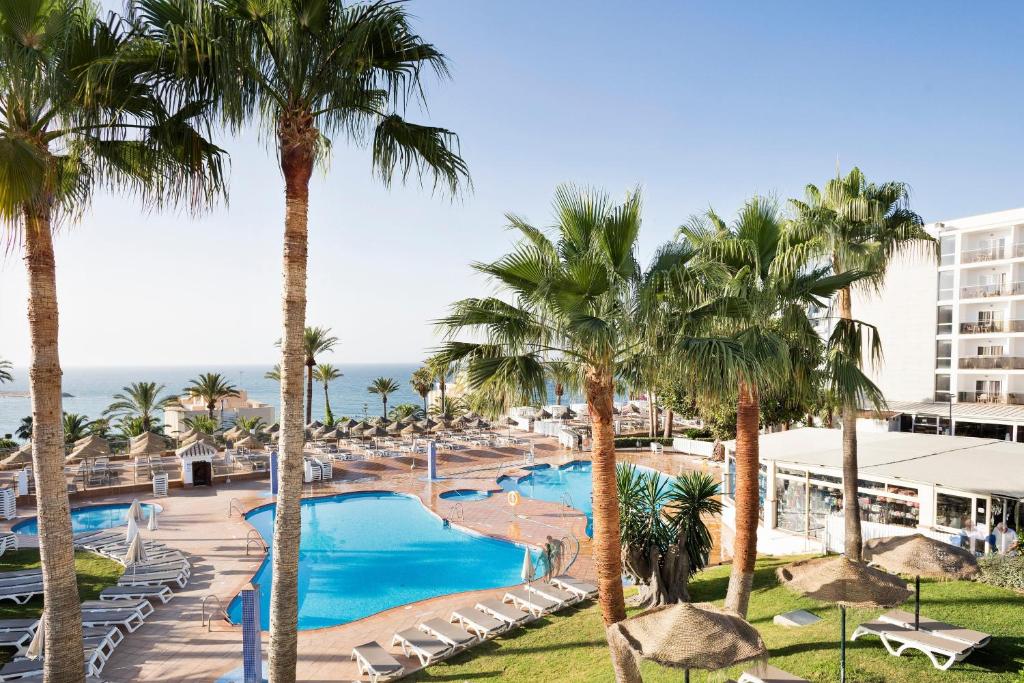 vista para a piscina num resort com palmeiras em Hotel Best Siroco em Benalmádena