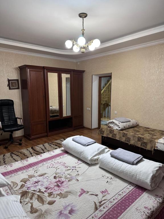 Cette chambre comprend deux lits et un lustre. dans l'établissement Amanat Hostel Bishkek, à Bishkek