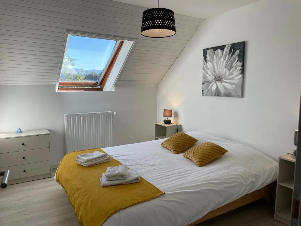 een slaapkamer met een groot wit bed en een raam bij Maison L'Aiguille - 2 appartements, 5 chambres et table d'hôtes au pied de la montagne à la station de Laye in Laye