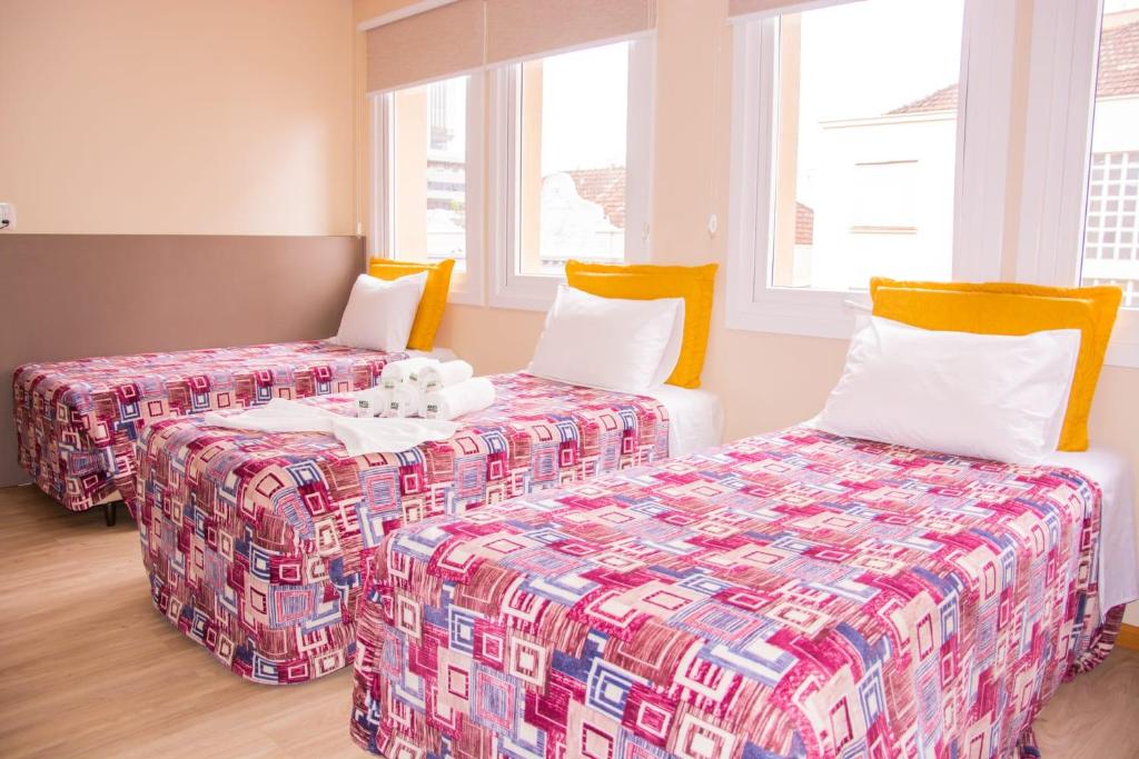 a room with two beds and two pillows at Nhtel Acomodações in Novo Hamburgo