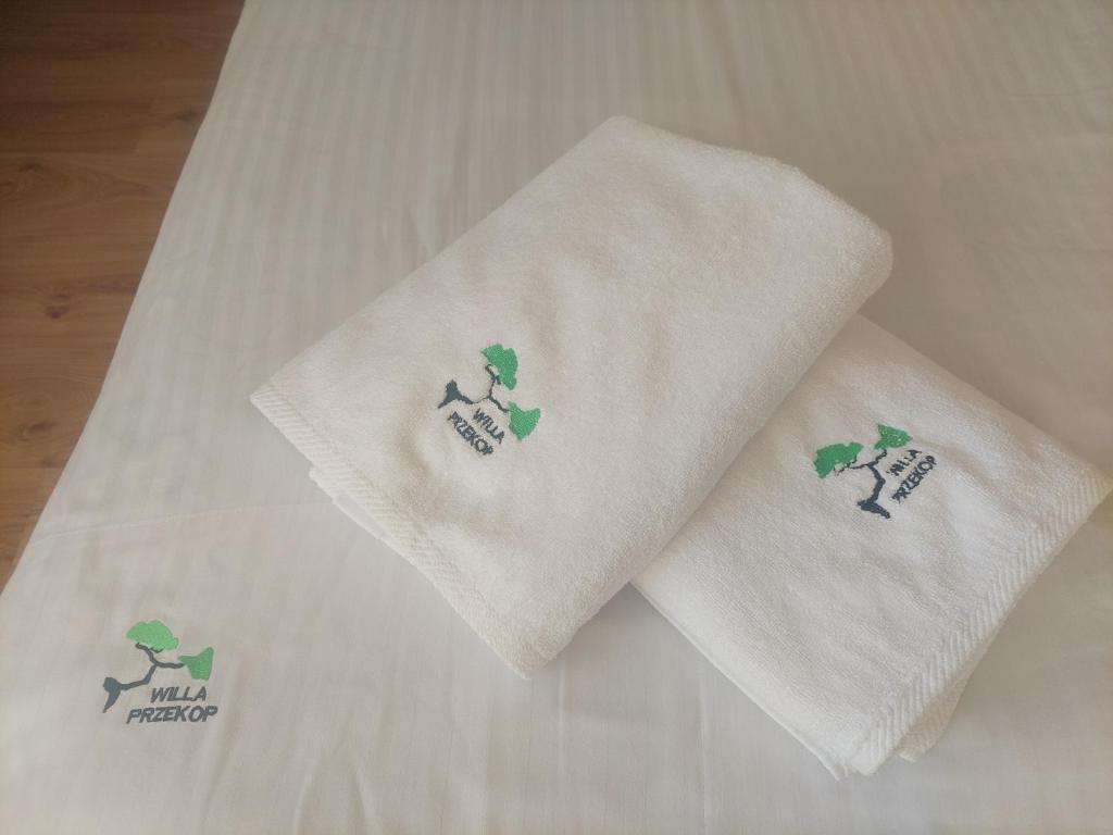 two towels with shamrocks on them on a bed at Willa Przekop - apartamenty in Sromowce Wyżne