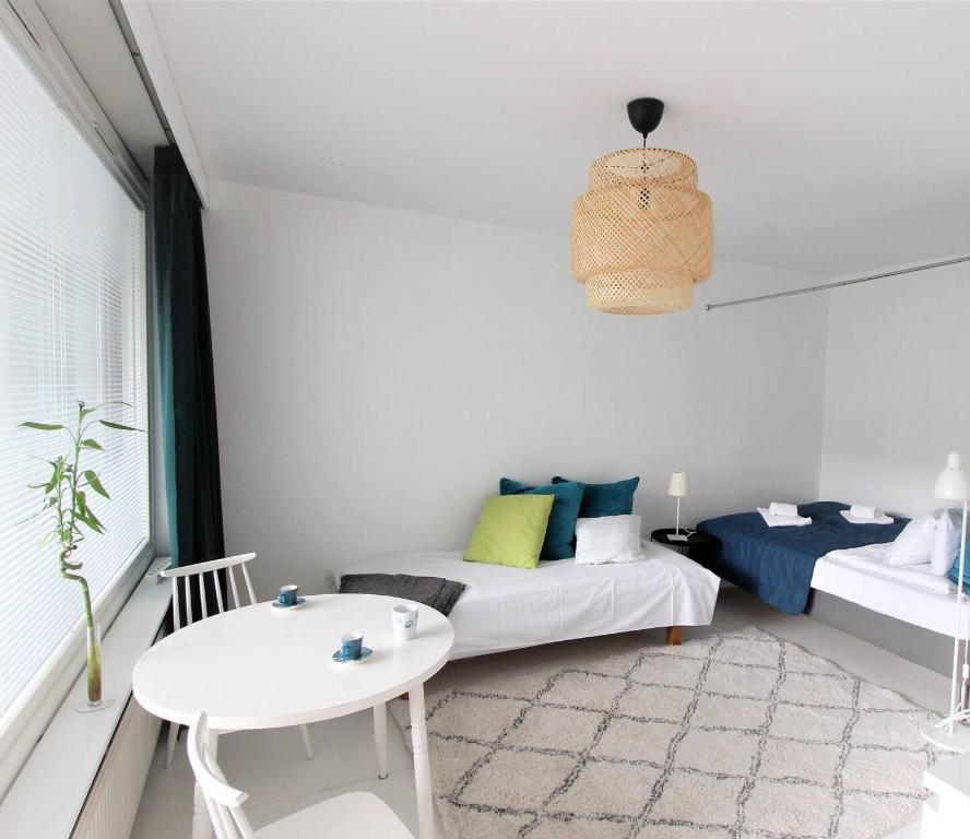 ein Wohnzimmer mit einem Sofa und einem Tisch in der Unterkunft Pasila Studio, Near Expo in Helsinki