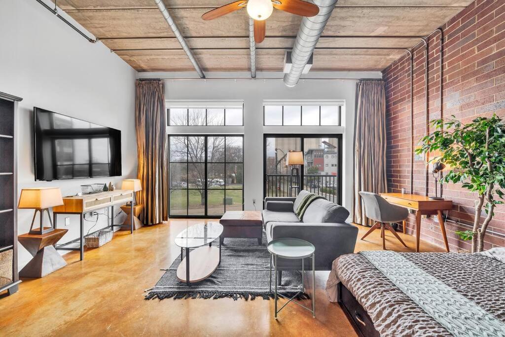 a bedroom with a bed and a couch and a table at Charming 1BR Condo - Full Kitchen - Uptown Living in Charlotte