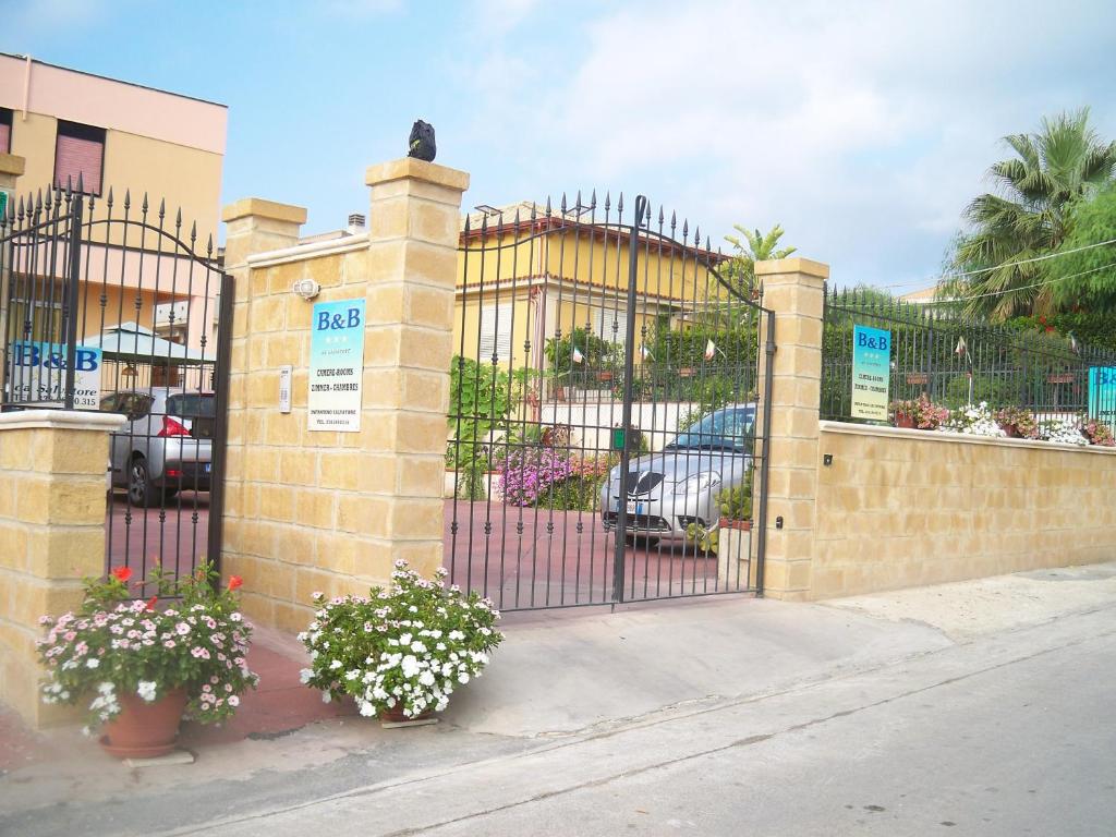 a wrought iron gate with potted plants and flowers at B&B Salvatore Lido di Noto in Noto Marina
